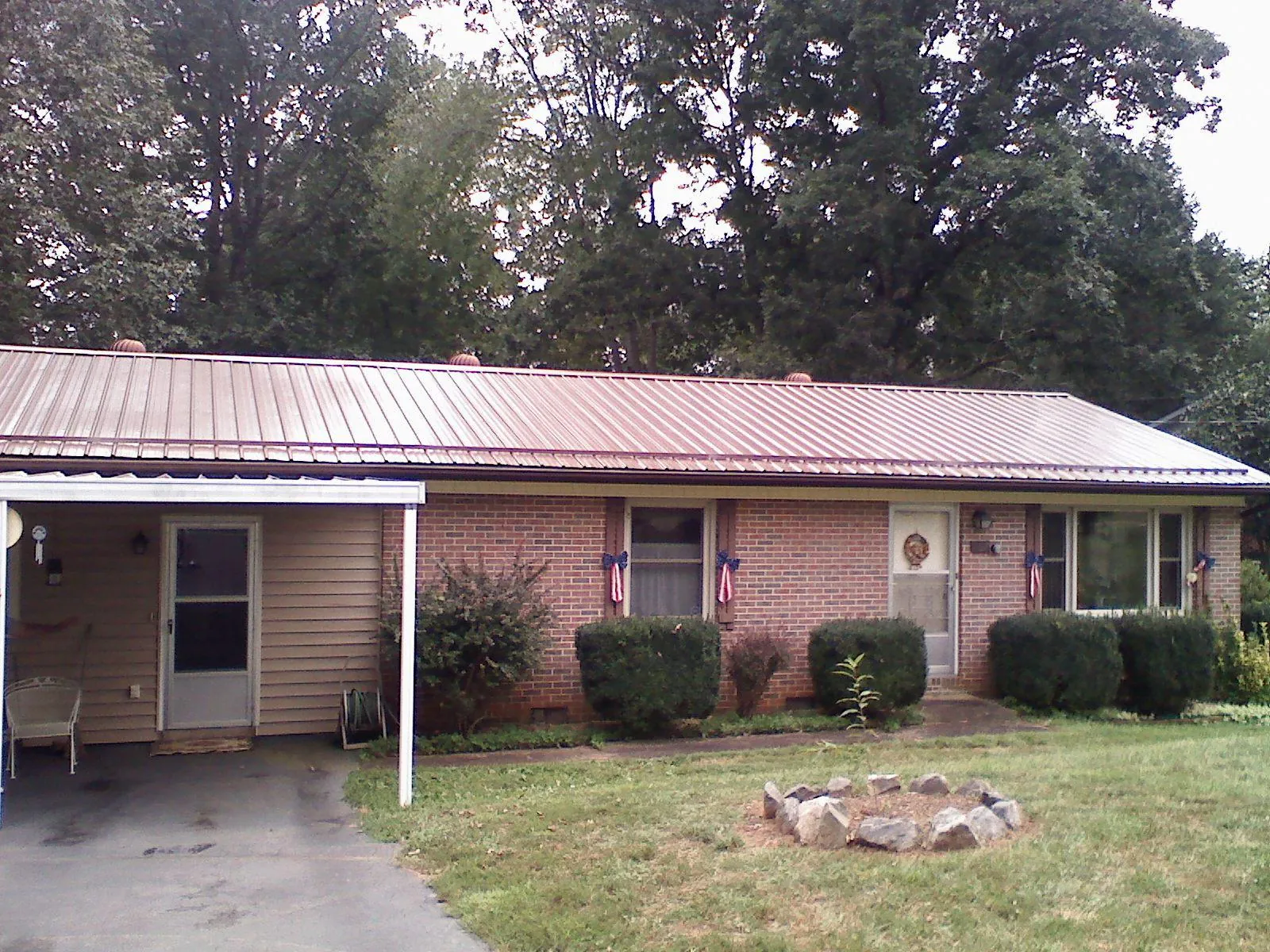 Bronze metal roof and carport on a brick ranch home — Roof Repair work by our crew in Schneider